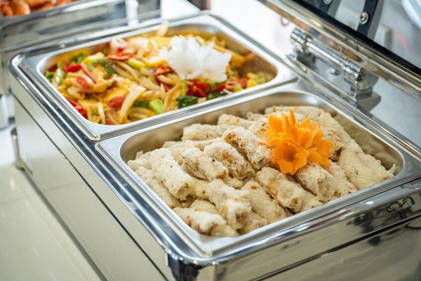 A buffet with various dishes, including a salad and a rice dish garnished with a flower. 3