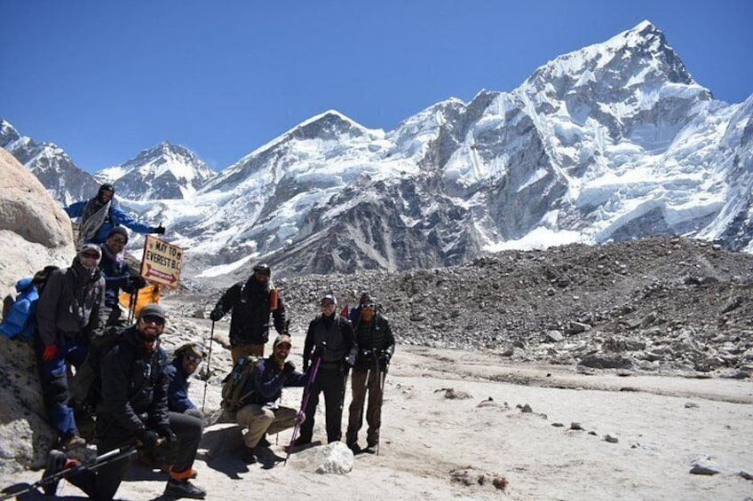 A group of people in a mountainous, snowy environment with a clear sky. 1