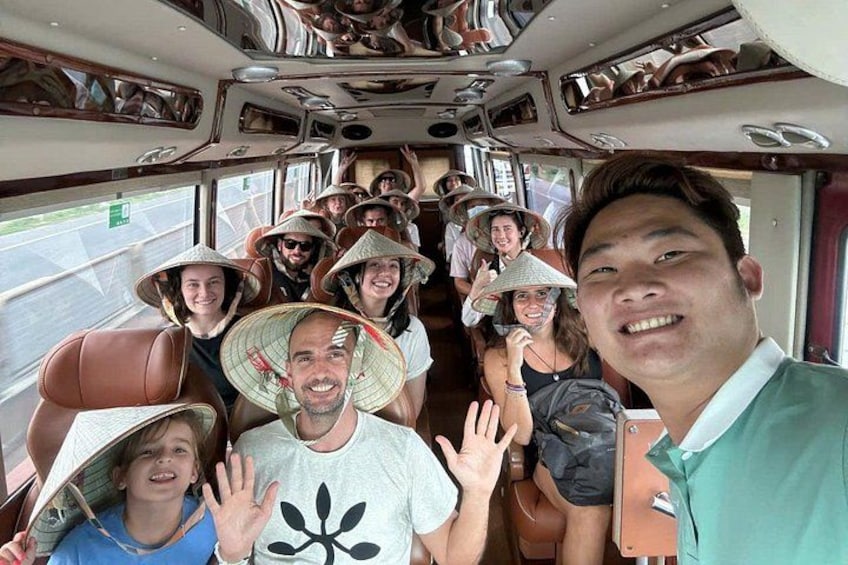 Un grupo de personas en un autobús, algunas usando sombreros cónicos tradicionales. 2