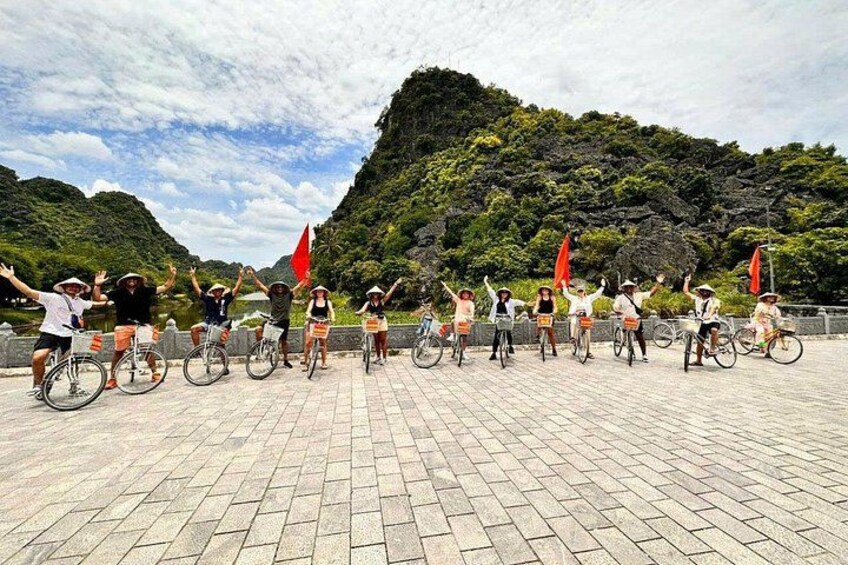 Un gruppo di persone in bicicletta esegue una coreografia sincronizzata su una superficie asfaltata, con montagne sullo sfondo. 2