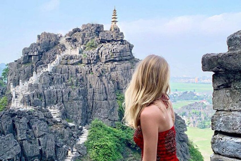 A person overlooking a rocky landscape with a pagoda on top. 1