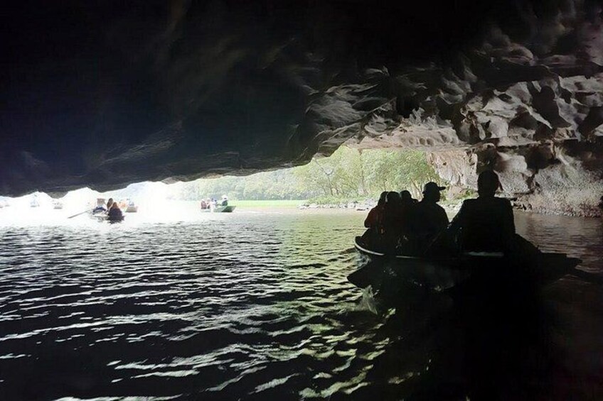 Une ouverture de grotte donnant sur l’eau, avec des bateaux. 2