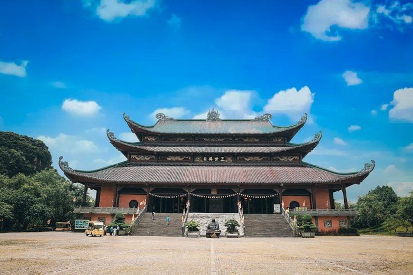 A traditional Chinese building with multiple tiers and a tiled roof, surrounded by a paved area with steps leading up to it. 1