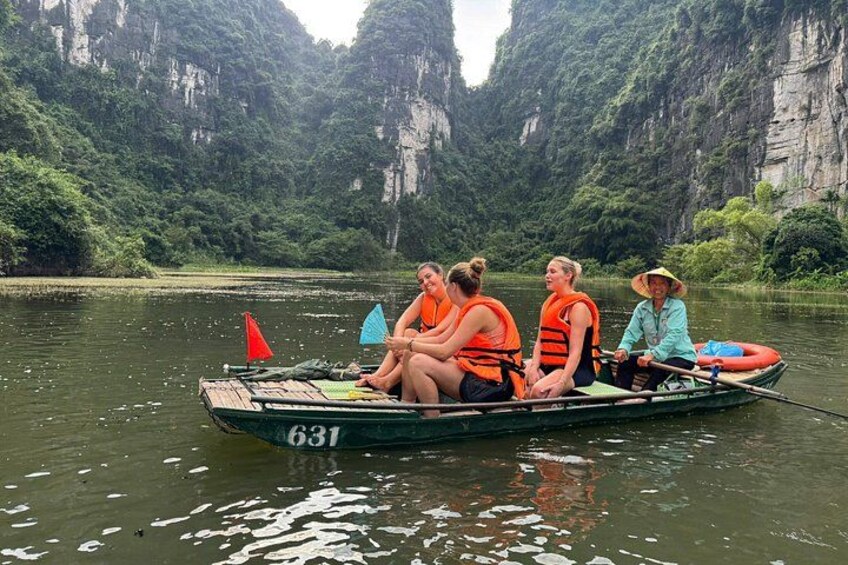 A group of people in a boat on a river surrounded by cliffs. 2