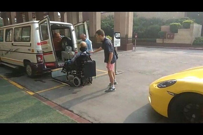 A van with its door open, a person in a wheelchair, and a yellow sports car. 5