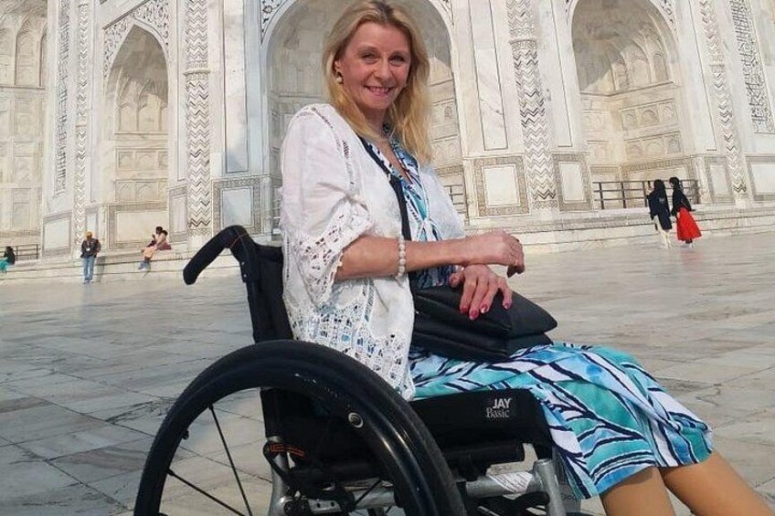 A person in a wheelchair in front of a large, ornate building with intricate architectural details. 4