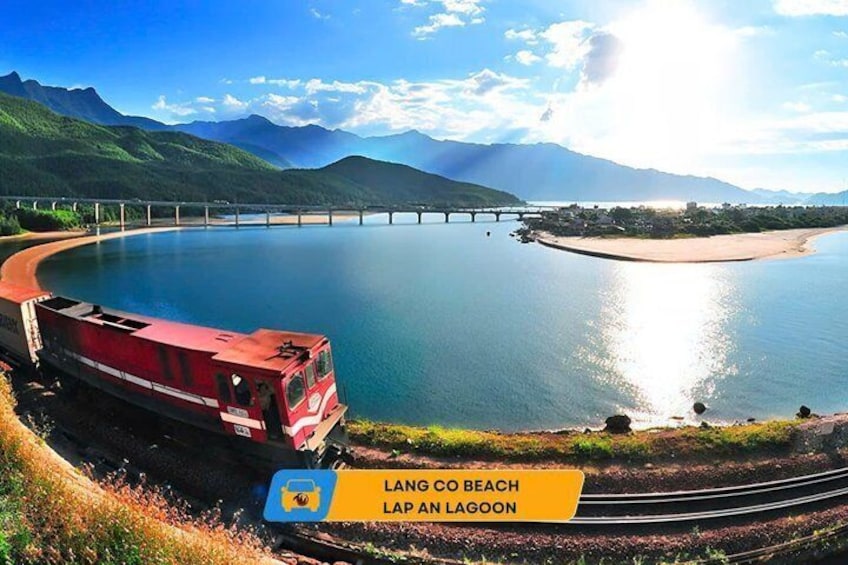 A red train at Lang Co Beach, Lap An Lagoon, with a bridge in the background. 3