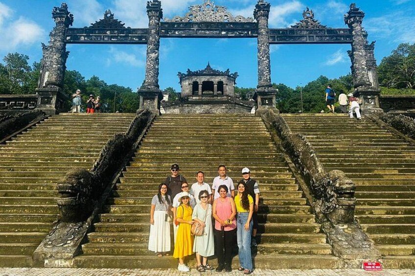 A group of people standing on ancient stone steps with a traditional gate in the background. 5