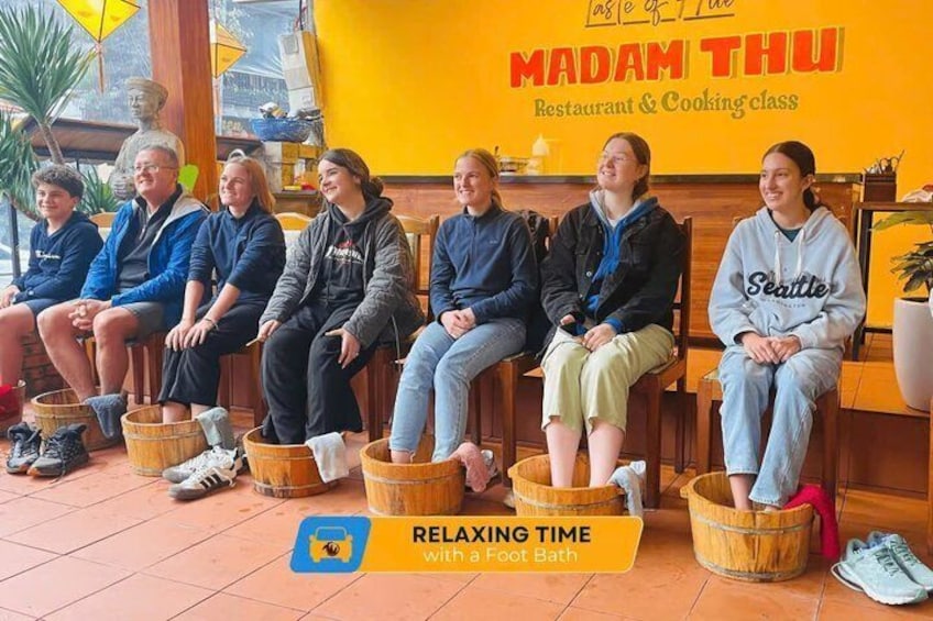 People sitting in wooden buckets at Madam Thu Restaurant & Cooking class. 4