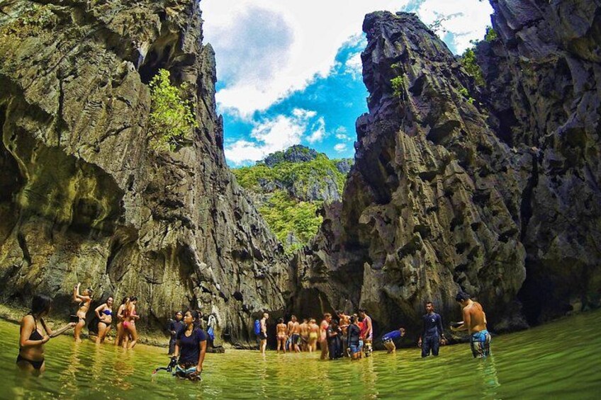 A group of people in a canyon with water at the base. 4