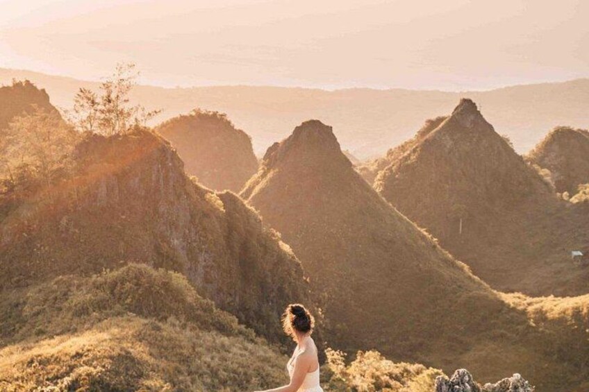 A person standing on a hill overlooking a valley with prominent hills. 3