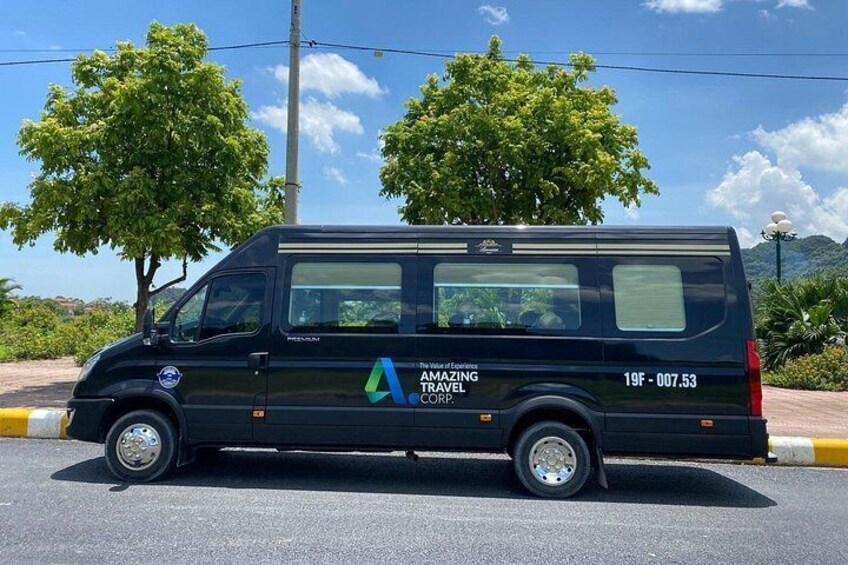 A black van parked on a road with trees and mountains in the background. 2