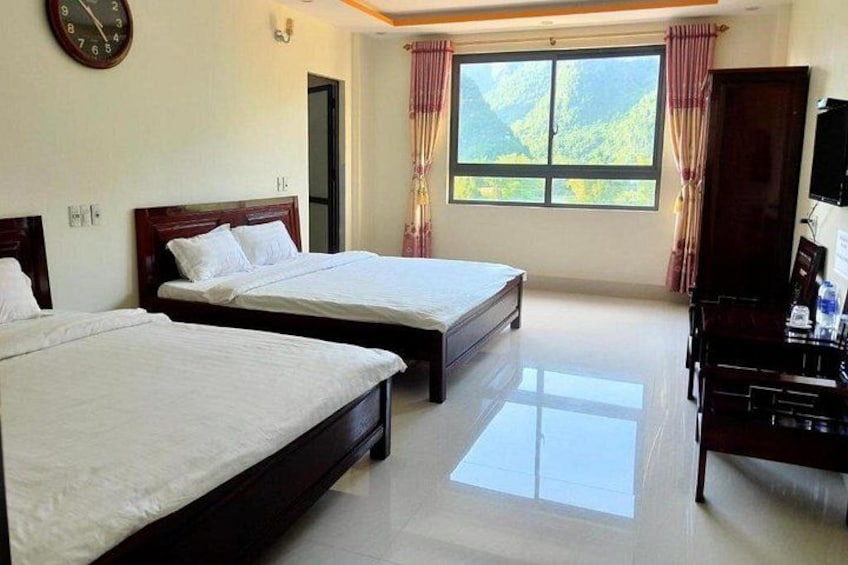A hotel room with two beds, a piano, a television, and a window with curtains. 5