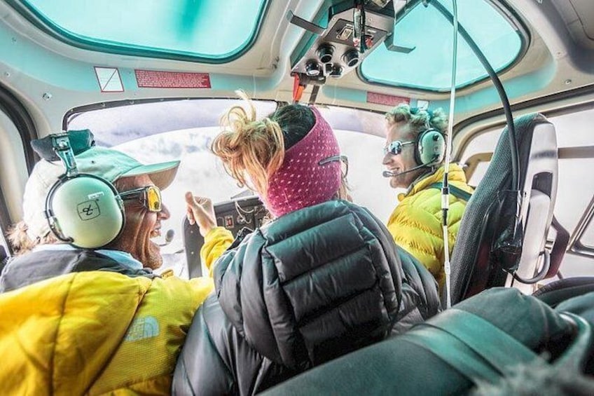 Helikoptercockpittens indre med passagerer iført sikkerhedsudstyr og høretelefoner. 2