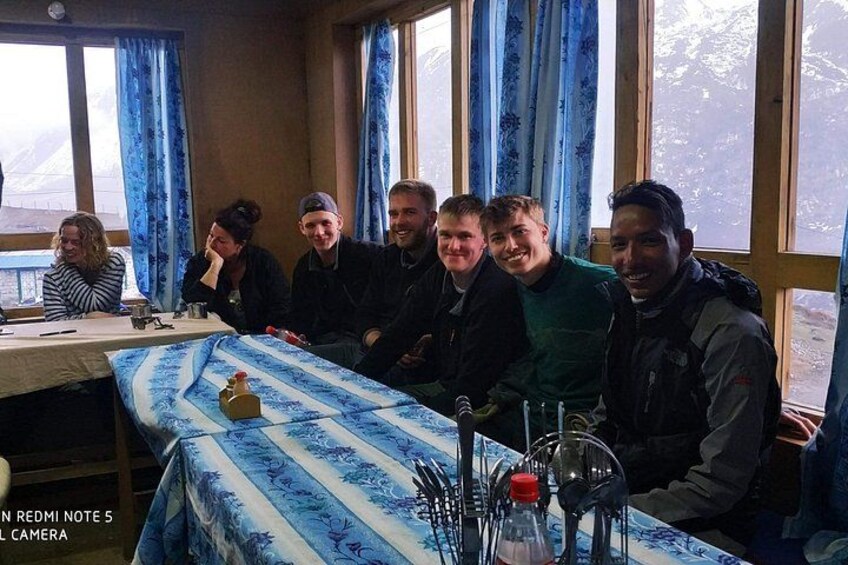 A group of people seated at a table with a blue and white patterned tablecloth. 4