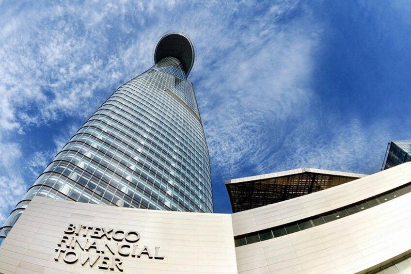 A tall, modern skyscraper with a curved glass facade and a distinctive top. 3