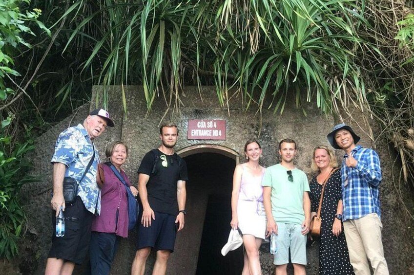 Un grupo de personas de pie frente a la entrada de una cueva, con un letrero que dice 'Cave Entrance No A'. 4