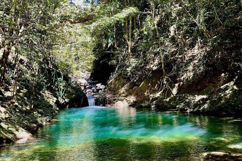A turquoise river surrounded by dense forest and rocky terrain. 4