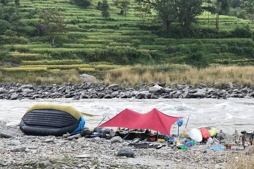 A river with a tent and a kayak. 4