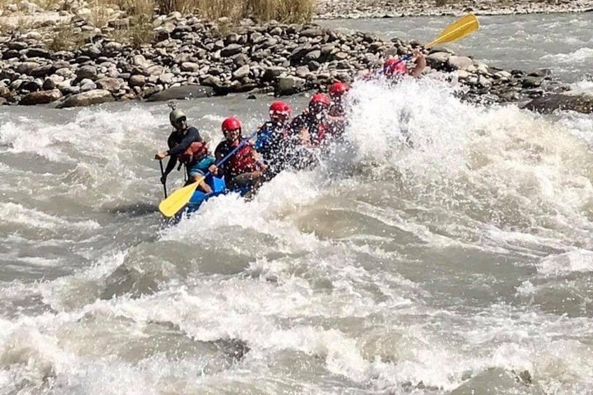 A group of people in a raft navigating a river with rapids. 3