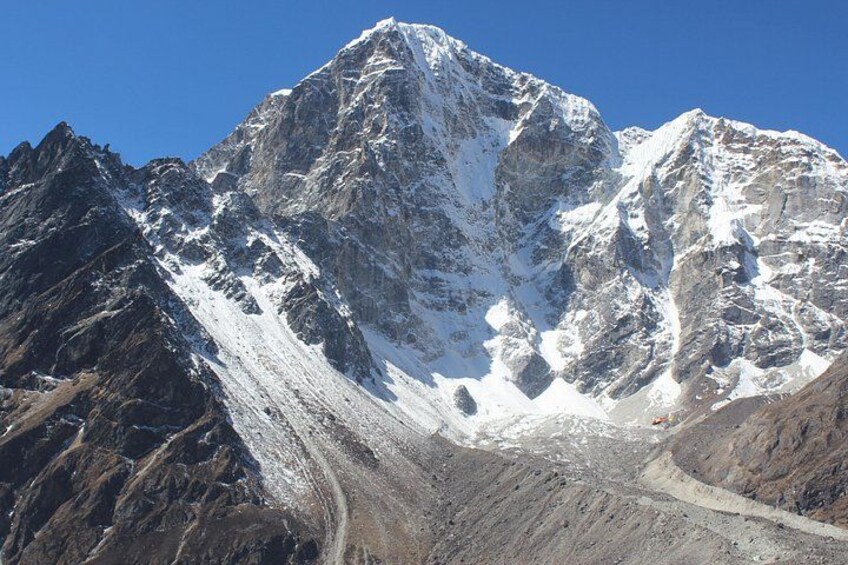 A snow-covered mountain peak with rugged terrain and a clear sky. 4