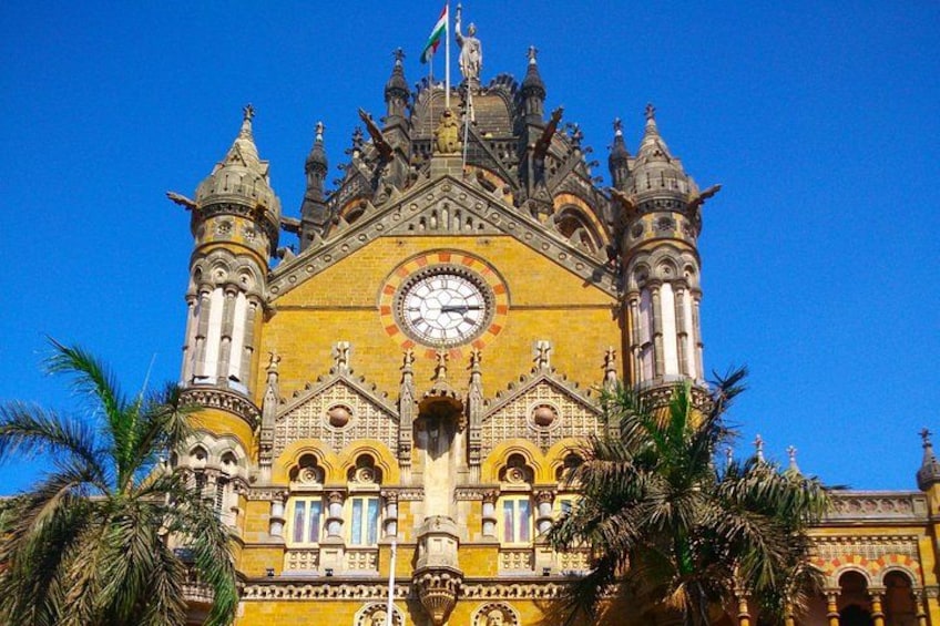 Un edificio histórico con arquitectura ornamentada, un reloj destacado y una bandera. 2
