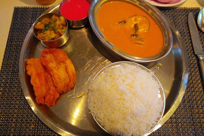 Un plato de comida con arroz, curry y alimentos fritos. 5