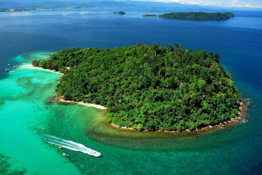 An island surrounded by turquoise waters with a boat near the shore. 5