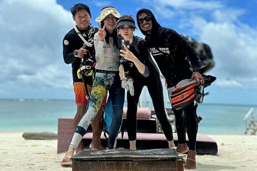 A group of people on a beach with a camera and a surfboard. 4