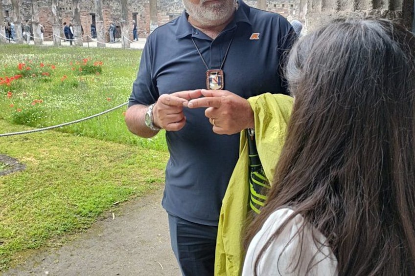 Een man in een donker poloshirt en een vrouw in een gele jas staan op een pad met een touwbarrière. 4