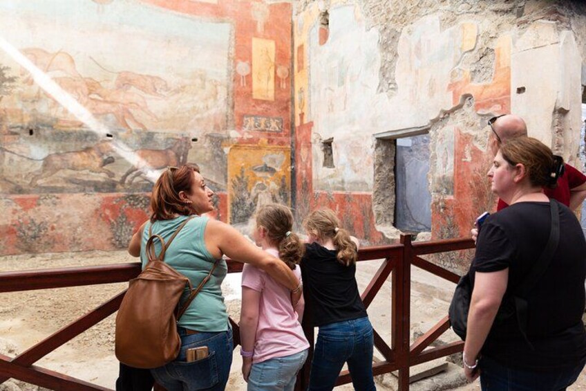 A group of people observing ancient frescoes in a museum. 3