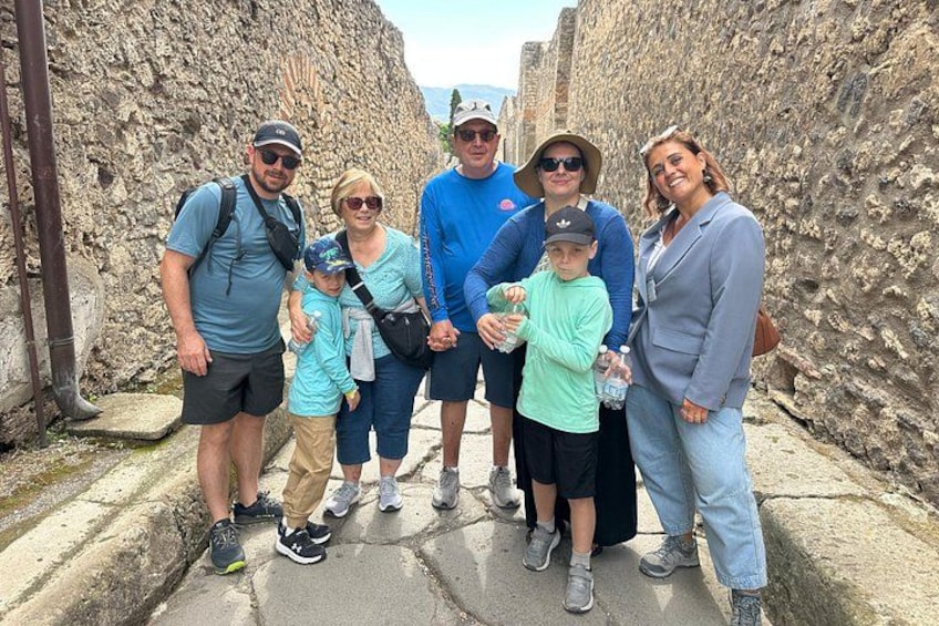 A group of people standing in a stone corridor with historical architecture. 5