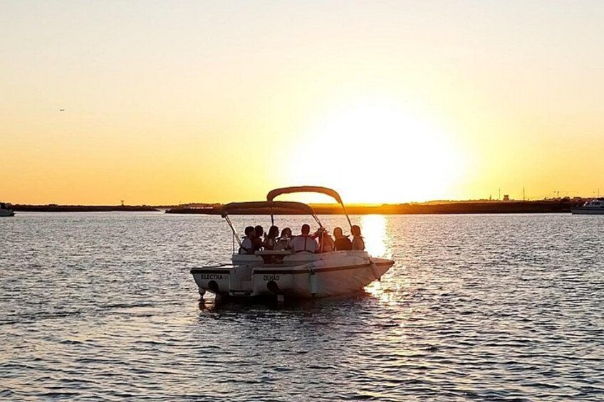 A boat with people on a body of water during sunset. 2