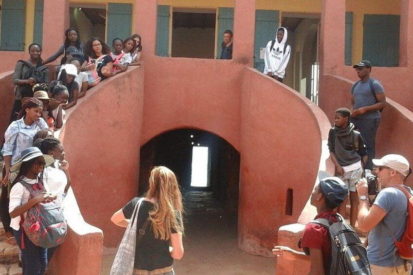 A group of people gathered around a building entrance with a large window. 1