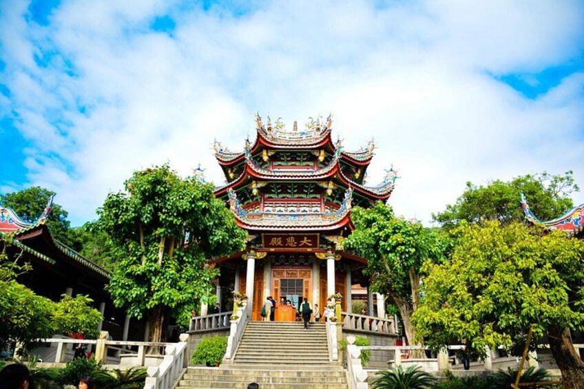A traditional Chinese temple with ornate architecture, a staircase leading up to the entrance, and lush greenery surrounding the structure. 4