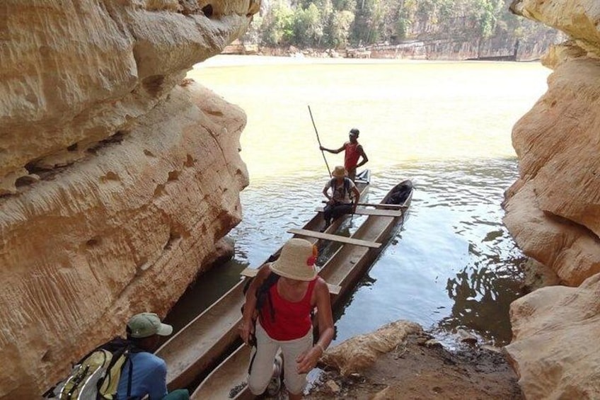 Un étroit canal bordé de grandes formations rocheuses, où l’on peut voir des personnes naviguer à bord d’un petit bateau. 3