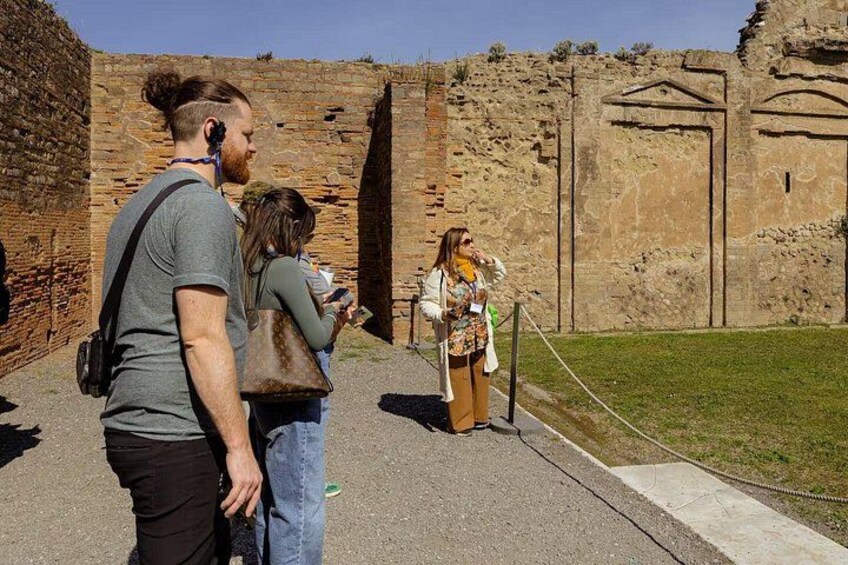 Turistas en un sitio arqueológico con ruinas antiguas y un guía. 2