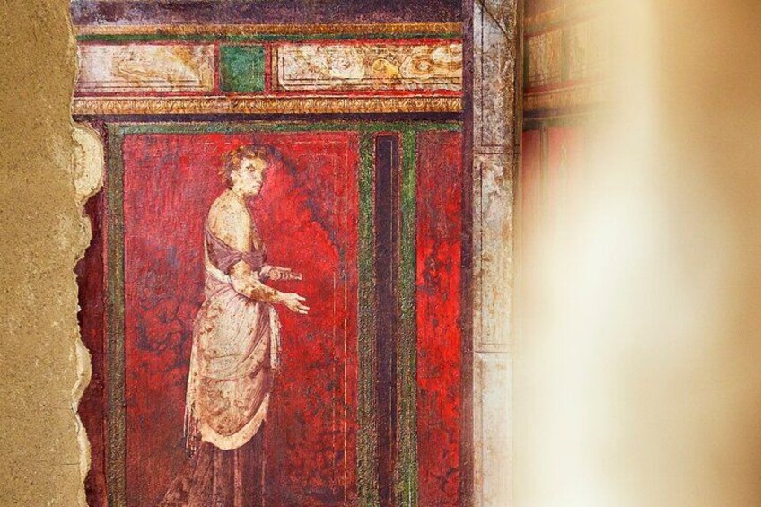 Fresco con una figura sobre fondo rojo, enmarcado por una decoración. 3