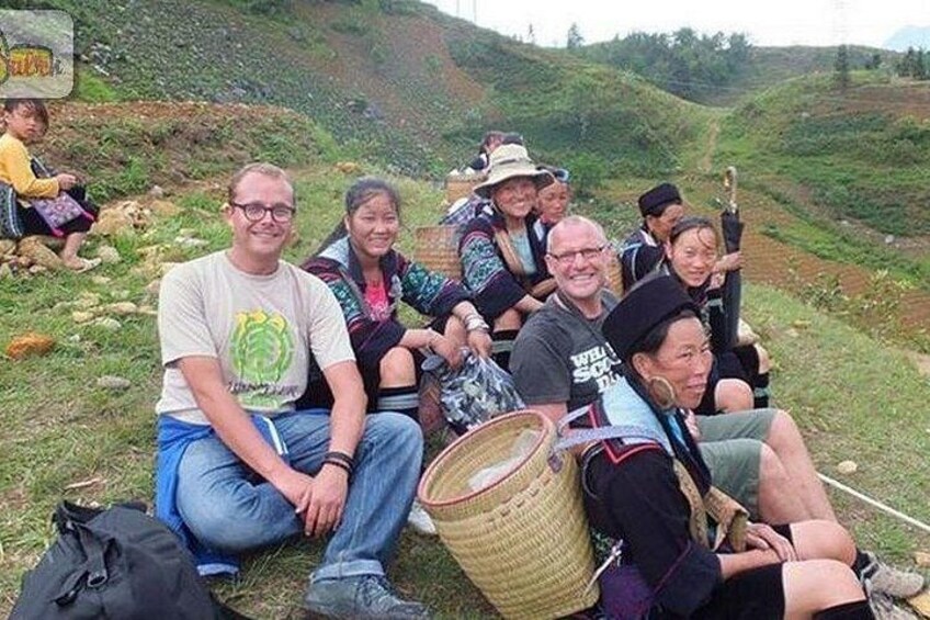 Een groep mensen die op het gras zitten in een heuvellandschap. 5