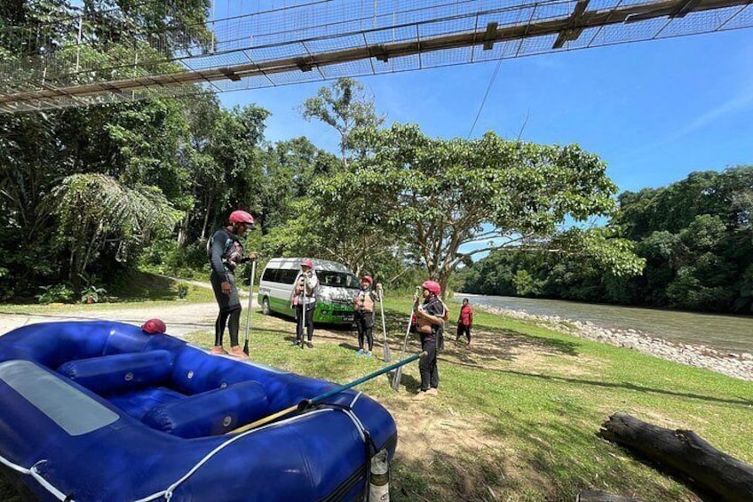 Un grupo de personas cerca de un río, un bote inflable azul y una camioneta blanca. 2