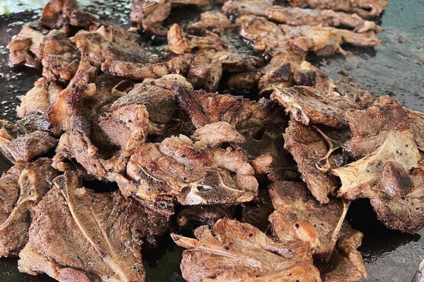 Un montón de carne cocida, probablemente res, con condimentos y marcas de quemado visibles. 3