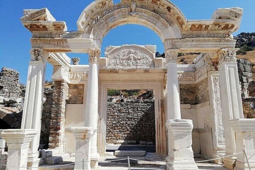 Ancient ruins with white columns and a central archway. 4