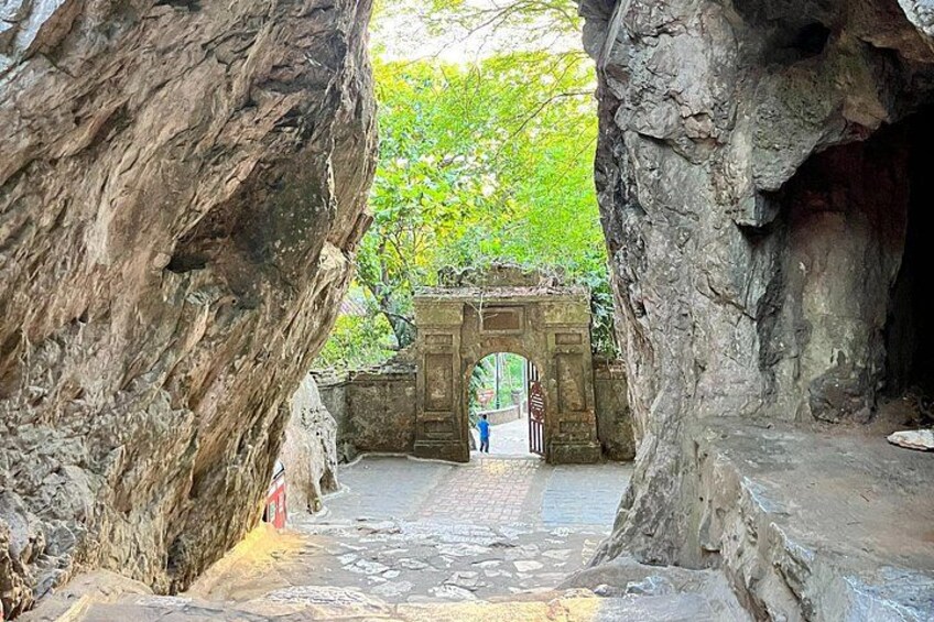 A stone pathway leading to a carved doorway framed by large rock formations. 3