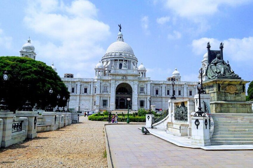 A large white building with a dome, a statue, and a fountain. 2