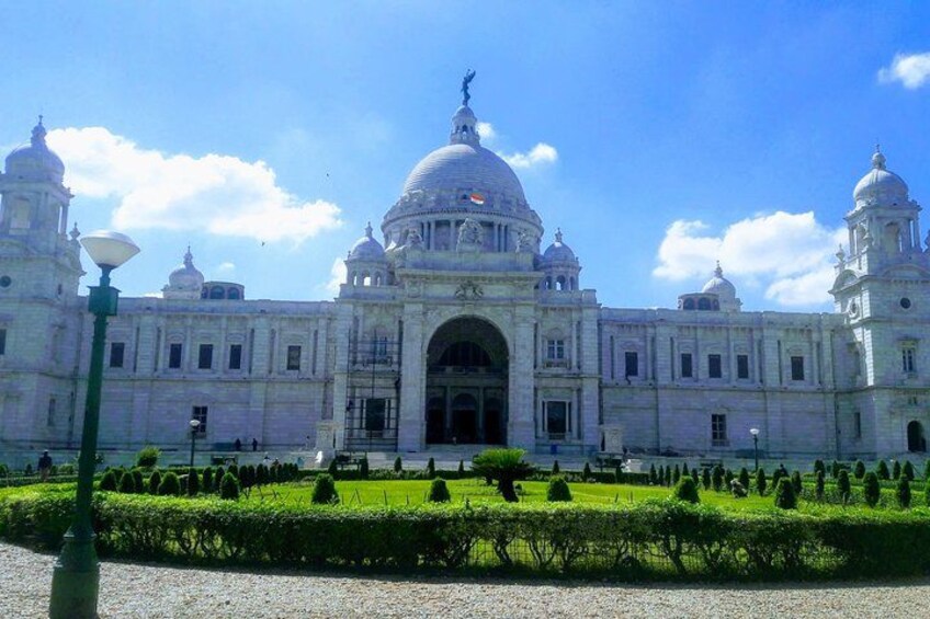A large white building with domes and columns, surrounded by a well-maintained garden. 3