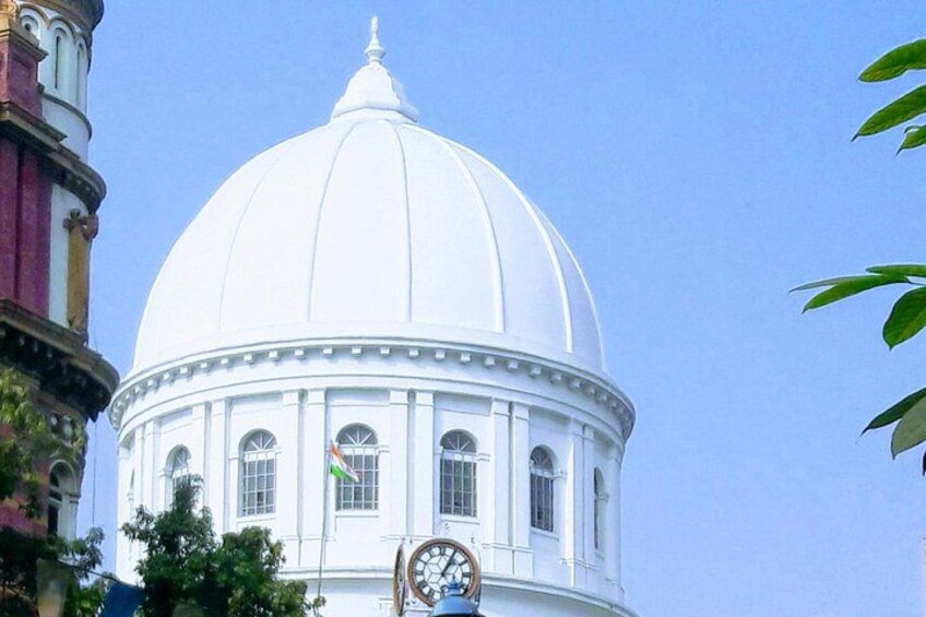 A white dome building with a clock and flag. 2