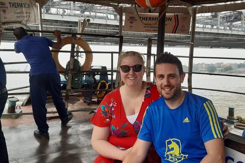 Two people on a boat with a bridge in the background. 3