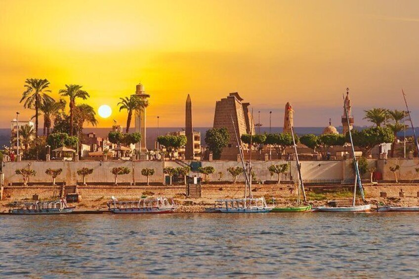 A sunset over a coastal city with palm trees, boats, and ancient structures. 4