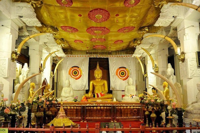 En gylden Buddha-statue i et tempel med detaljeret arkitektur og blomsterudsmykning. 4