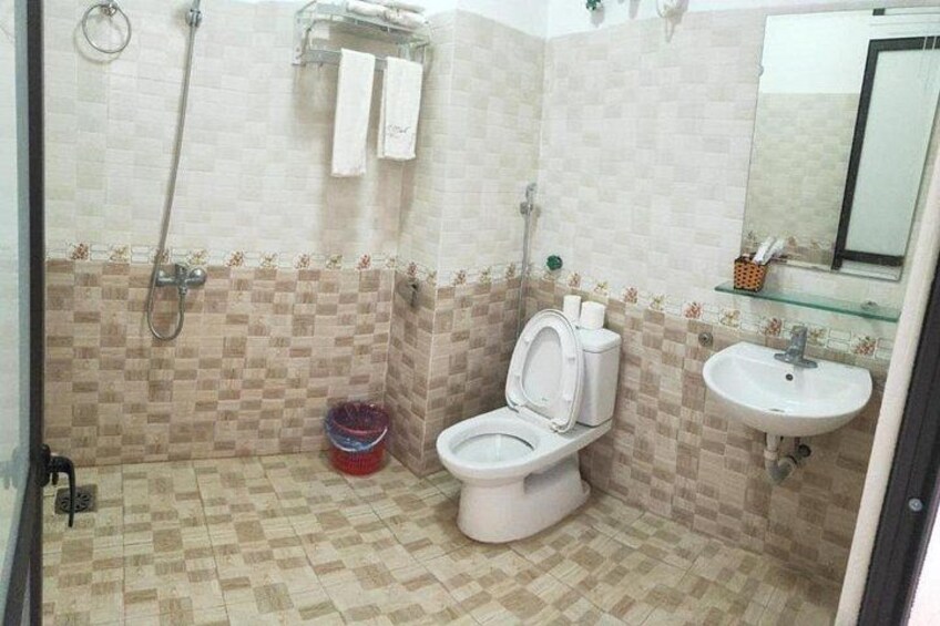 Ein Badezimmer mit Toilette, Waschbecken und Dusche. 2